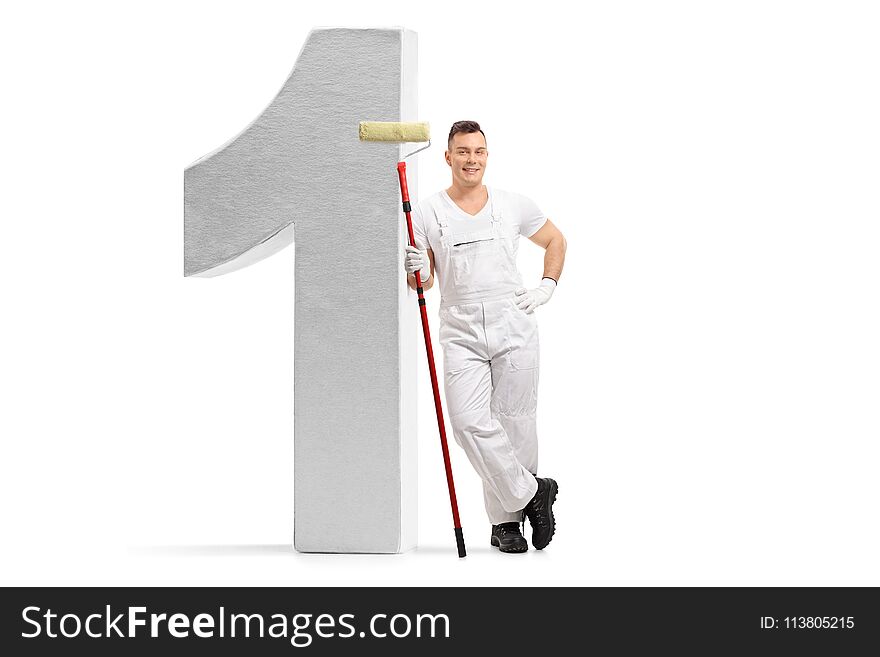 Full length portrait of a painter holding a paint roller and leaning against a number one figure isolated on white background