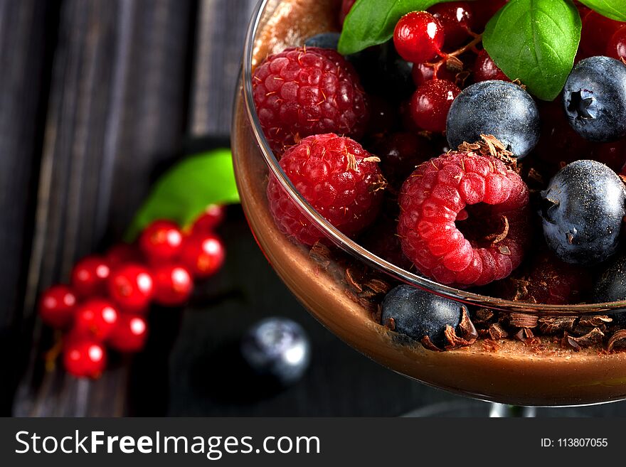 Ideas for a healthy diet. Dietary Chocolate mousse, parfait with fresh berries of raspberries, blueberries and red currants in a glass goblet