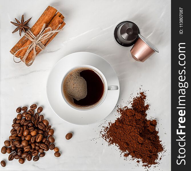 Espresso cup, coffee beans, coffee ground, coffee capsule and cinnamon with anise on a white background