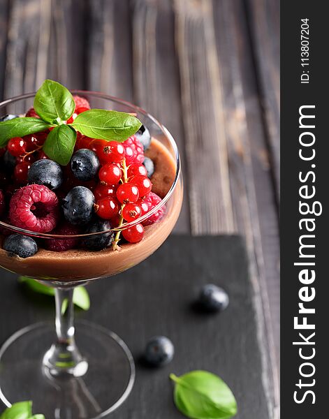 Ideas for a healthy diet: Dietary Chocolate mousse, parfait with fresh berries of raspberries, blueberries and red currants in a glass goblet