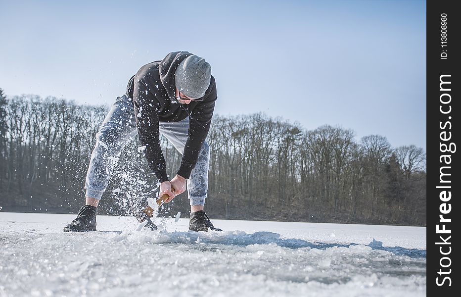 Person Holding Shovel on Snow Field