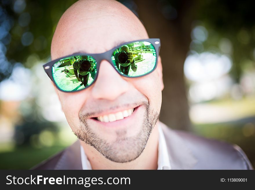 Shallow Focus Photography of Man in Gray Top Wearing Green Sunglasses With Black Frames