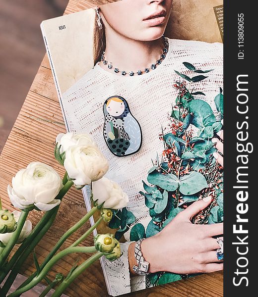 Woman Wearing Gray Crew-neck Shirt Printed Book on Brown Wooden Surface