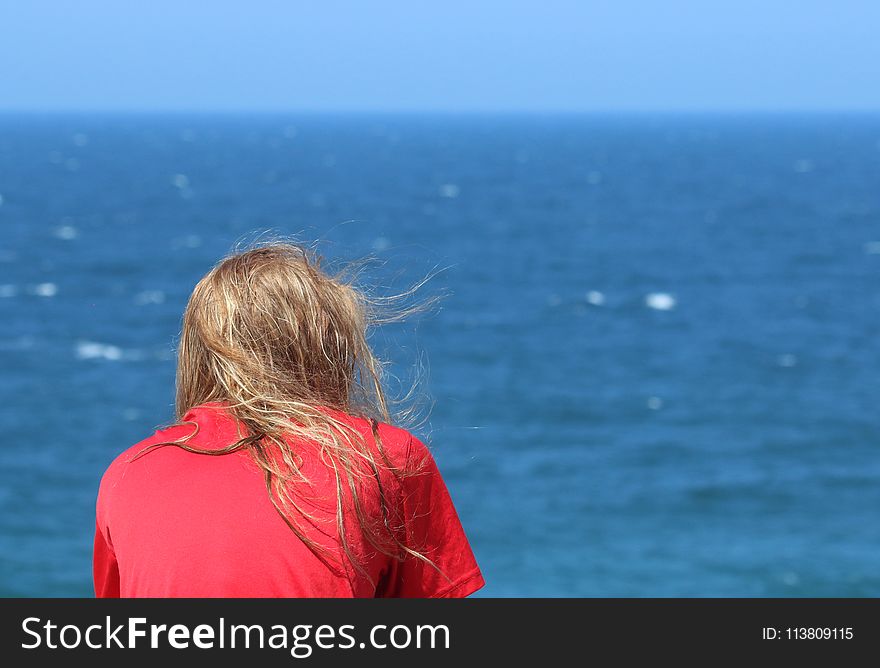 Person Wearing T-shirt Sitting Beside Seashore