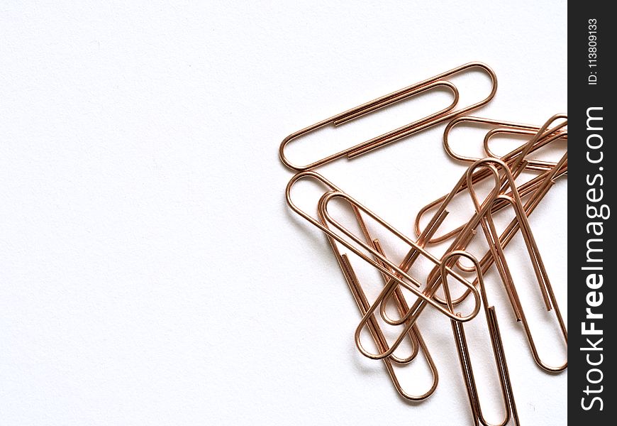Brass-colored Paper Clips on White Surface