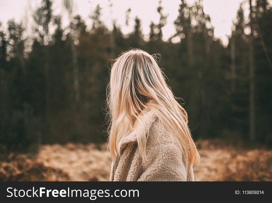 Depth of Field Photography of Woman Wearing White Coat Near Trees