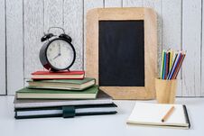Education Workspace Background Concepts Alarm Clock, Color Pencil In Wooden Cup And Chalkboard With White Wooden Vintage Wall Royalty Free Stock Image