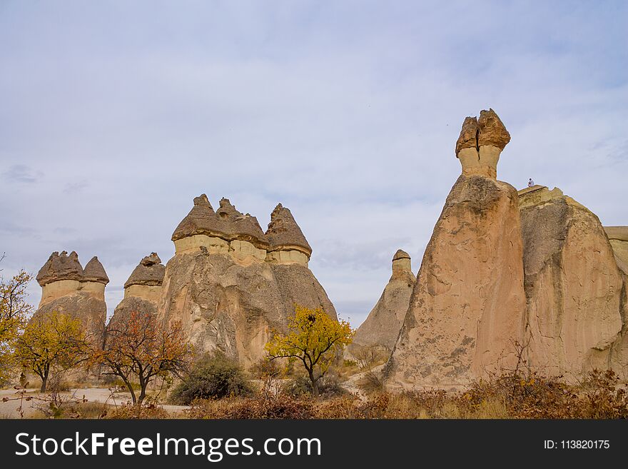 Tuff rock formations with caves in the valley of Cappadocia, Kapadokya, Turkey. fairy chimneys tall, cone-shaped rock formations clustered in Monks Valley, Goreme. Tuff rock formations with caves in the valley of Cappadocia, Kapadokya, Turkey. fairy chimneys tall, cone-shaped rock formations clustered in Monks Valley, Goreme
