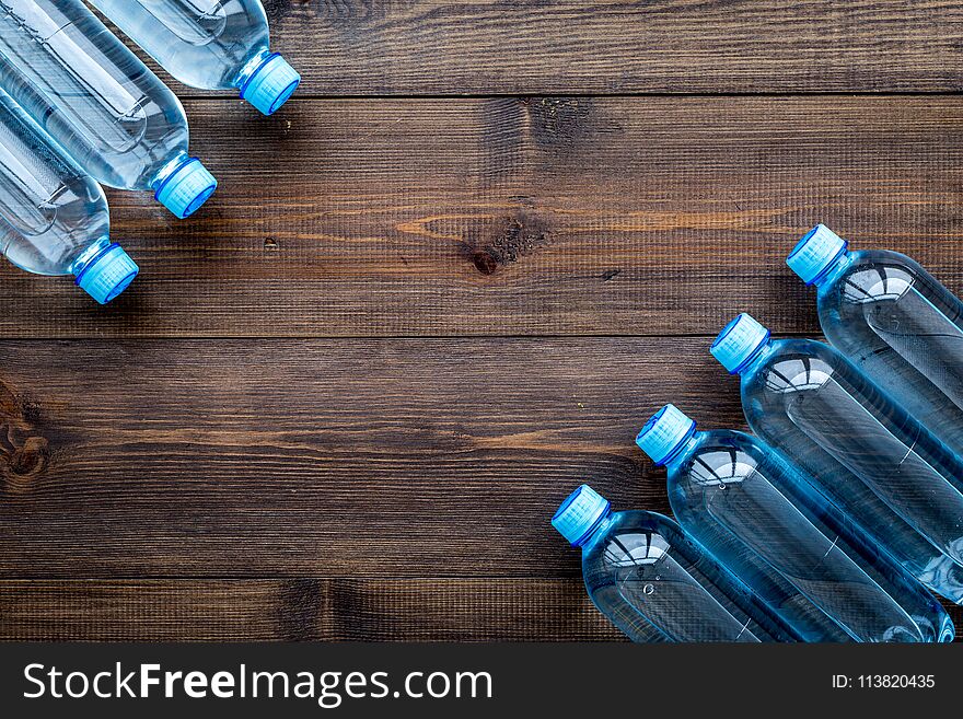 Drinking water in bottles on dark wooden background top view. Drinking water in bottles on dark wooden background top view.