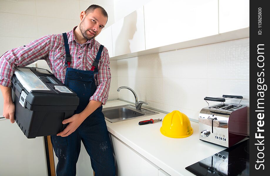 Handsome Man Standing In The Kitchen With His Toolbox