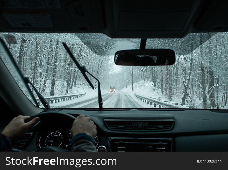 A commuter driving on icy roads in a winter snow storm in New England. A commuter driving on icy roads in a winter snow storm in New England