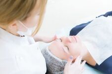 Beauty Saloon. Close-up Of A Medical Beautician In Pink Gloves Makes A Face Massage Of A Beautiful Woman. Cosmetology Royalty Free Stock Image