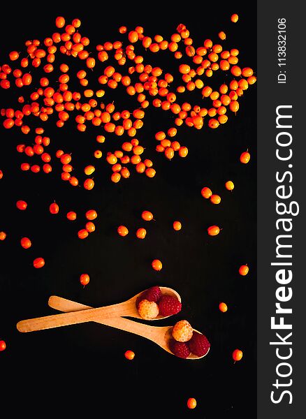 Orange sea-buckthorn background, isolated on a black background, falling down.