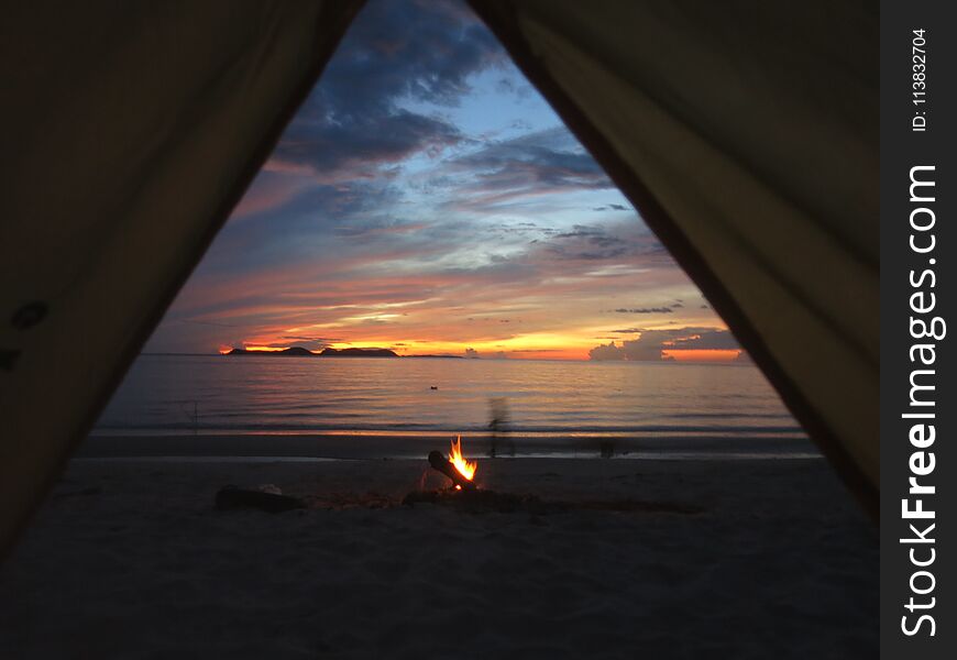 Sunrise view from a tent in Thailand with beach fire