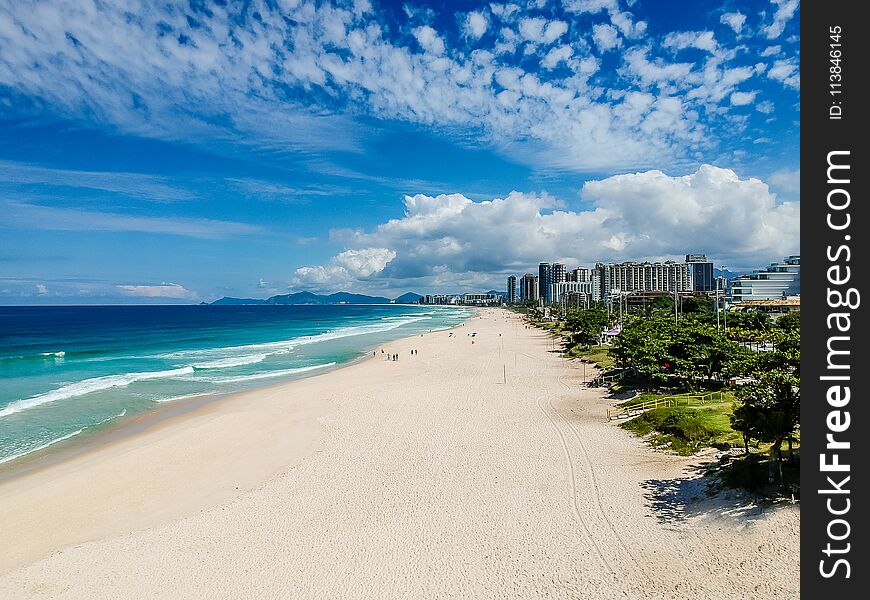 Drone photo of Barra da Tijuca beach, Rio de Janeiro, Brazil. We can see the beach, some building, the boardwalk, the road and the horizon