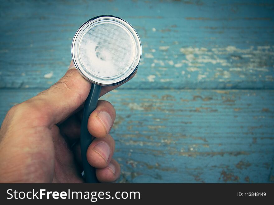 The hand holding a stethoscope