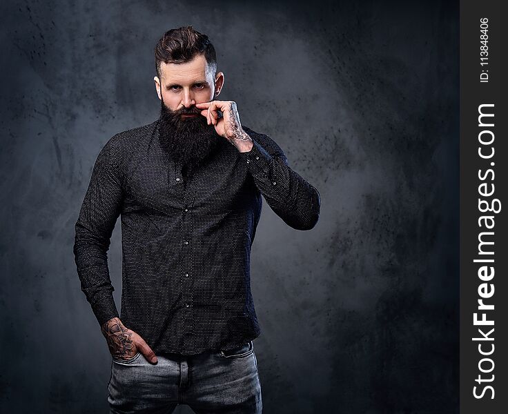 Stylish bearded male in a black shirt with tattoos on his arms. Stylish bearded male in a black shirt with tattoos on his arms.