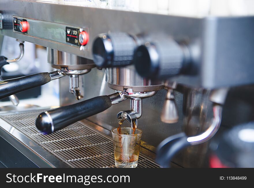 Prepares espresso in his coffee shop ; close-up , vintage tone