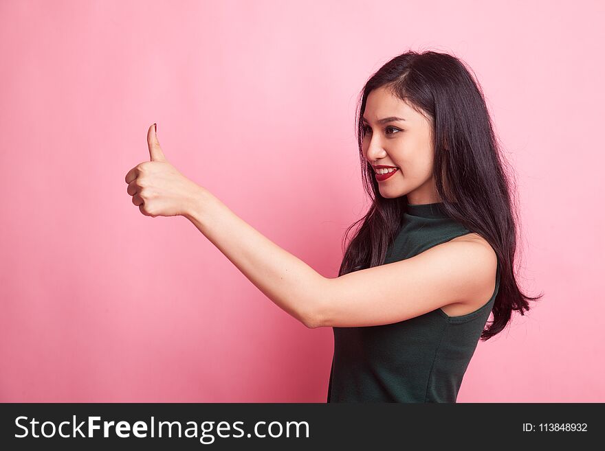 Asian woman thumbs up and smile on pink background. Asian woman thumbs up and smile on pink background