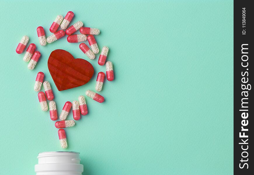 Meny different white and pink pills. Medicine background from much capsules. Drugstore set. Red heart