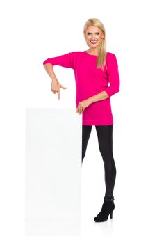 Beautiful Blond Woman Is Smiling And Pointing At Blank White Board Royalty Free Stock Photos