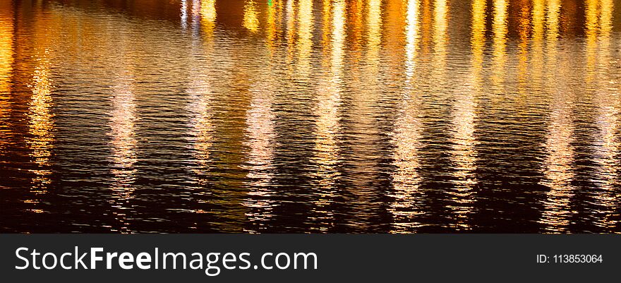 Light Of Lanterns On The Smooth Surface Of Water At Night As A Background