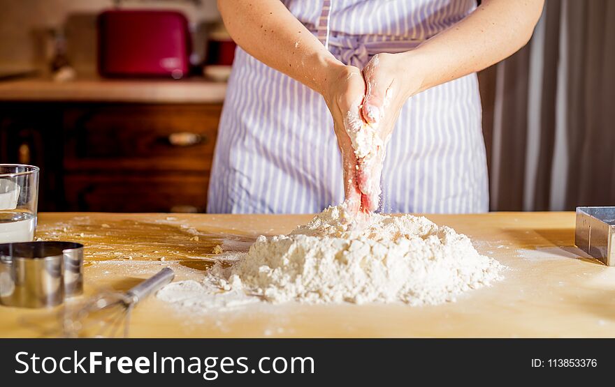 Woman`s Hands Knead Dough On A Table