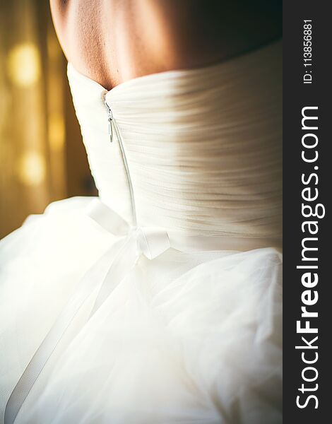 Back of bride in white wedding dress zipper. Back of bride in white wedding dress zipper