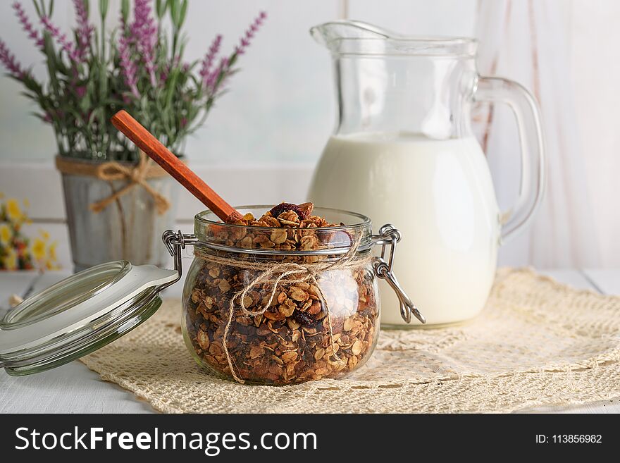 Homemade granola with nuts, cranberries and dried apricots, and a jug of milk. selective focus, copy space. Homemade granola with nuts, cranberries and dried apricots, and a jug of milk. selective focus, copy space