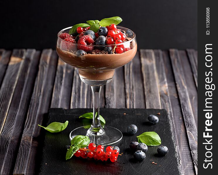 Ideas for a healthy diet. Dietary Chocolate mousse, parfait with fresh berries of raspberries, blueberries and red currants in a glass goblet