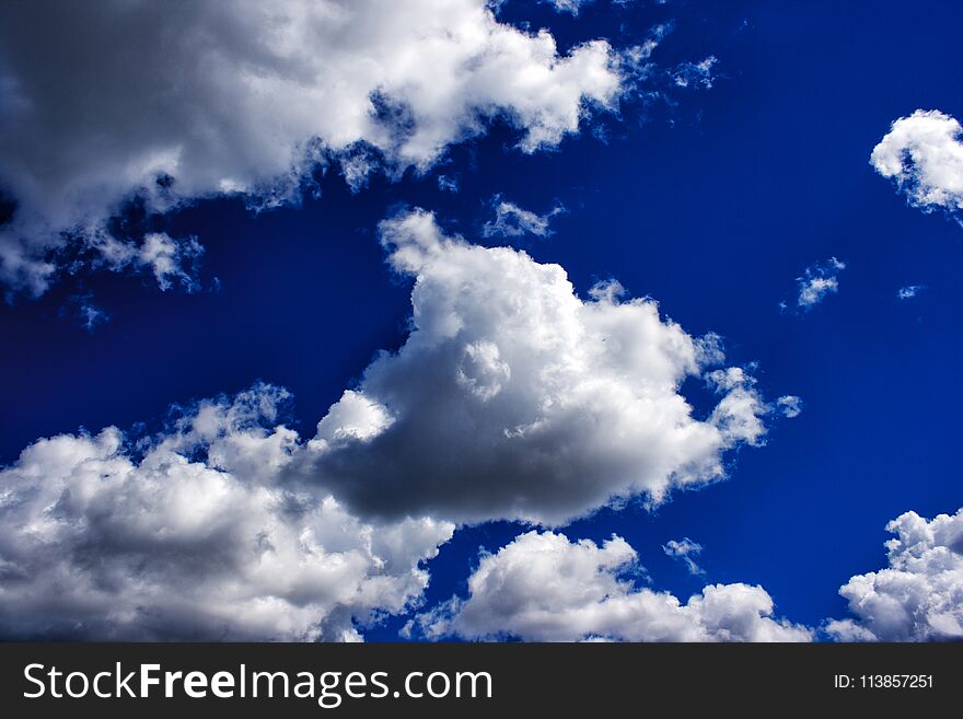 White clouds in the bright blue sky on sunny summer day