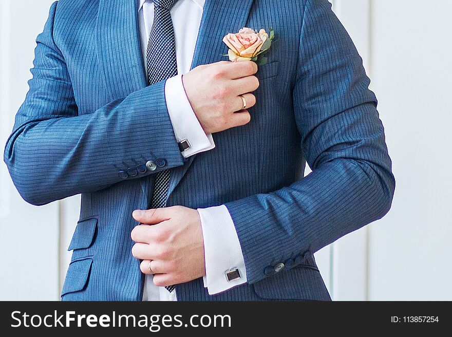 Groom Straightens The Flower In His Buttonhole