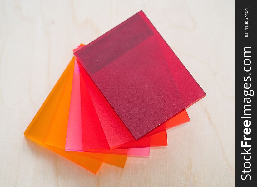 Colorful Pieces Of Matte Plexiglass On A Wooden Background.