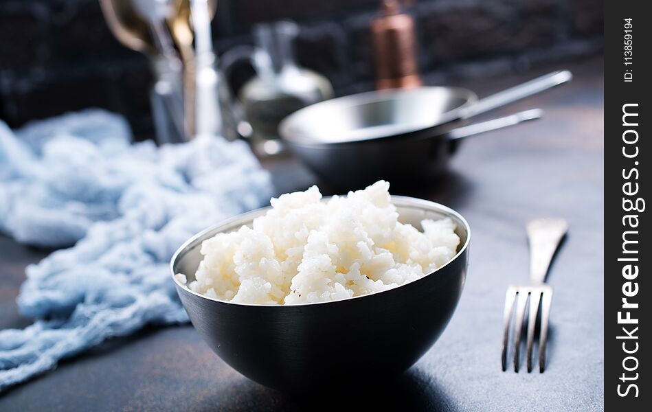 Boiled rice in bowl and on a table