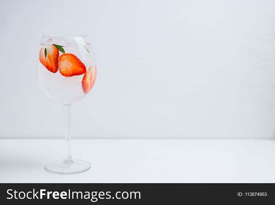 Gin with strawberry and ice in wine glass