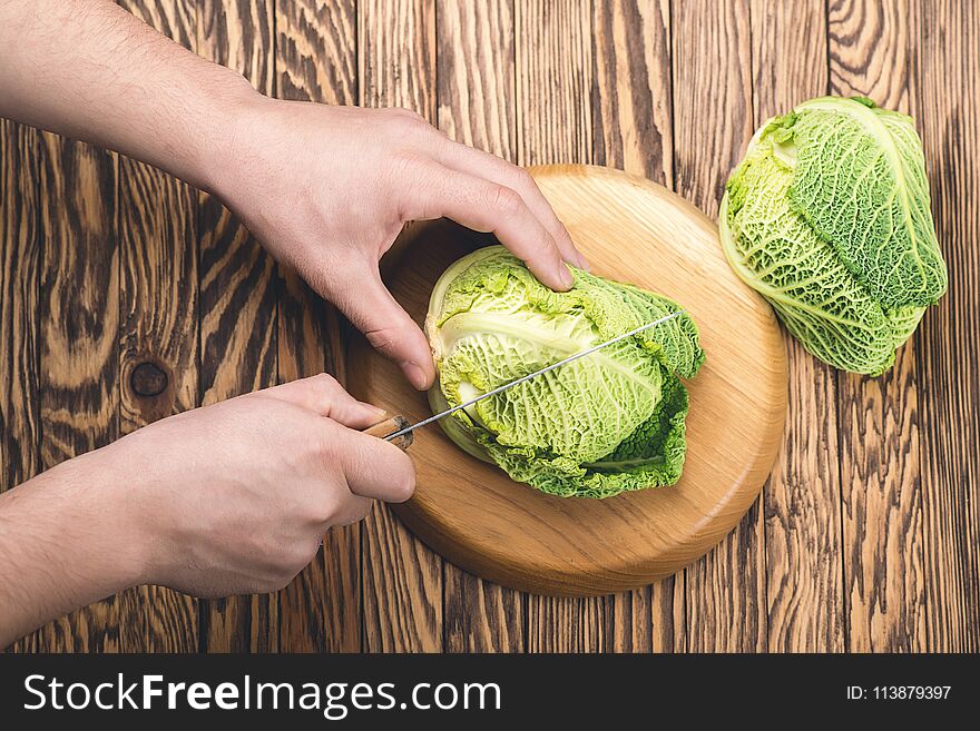 Man hands cutting fresh cabbage for salad, top view, close up. Man hands cutting fresh cabbage for salad, top view, close up.