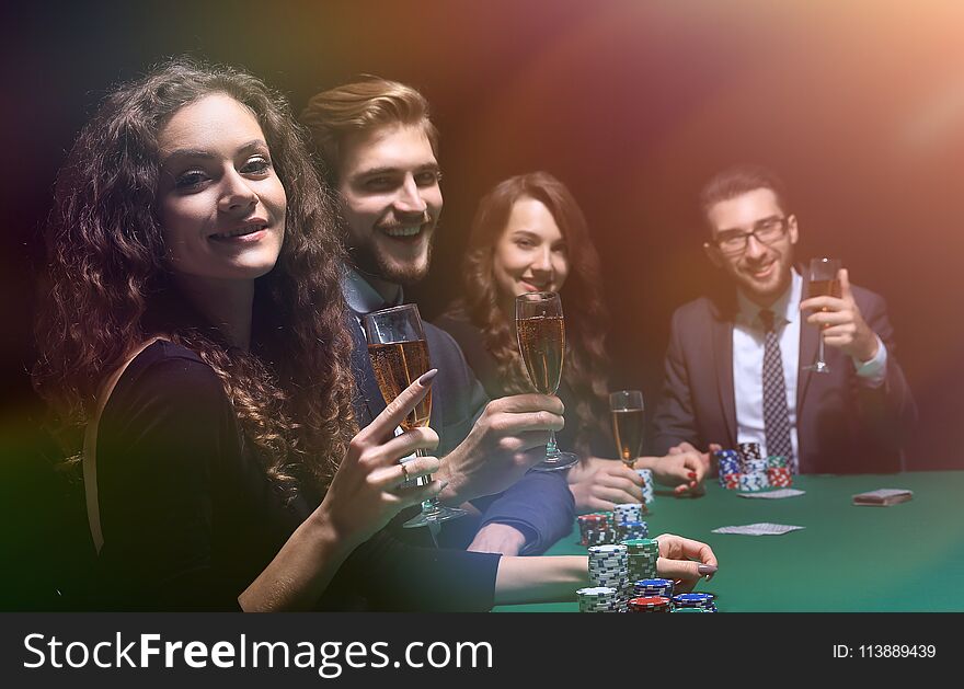 Poker players sitting around a table at a casino