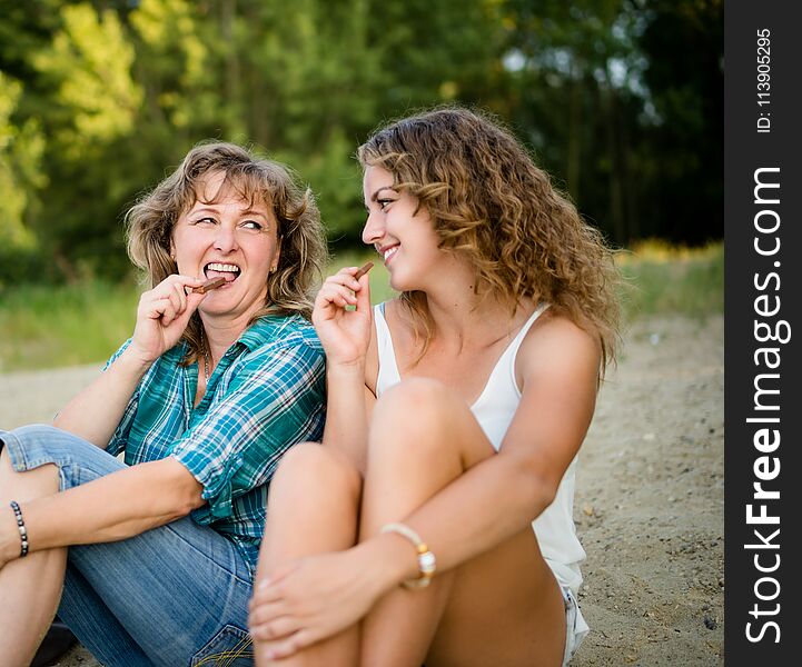 Mother And Daughter Enjoying Chocolate Bar