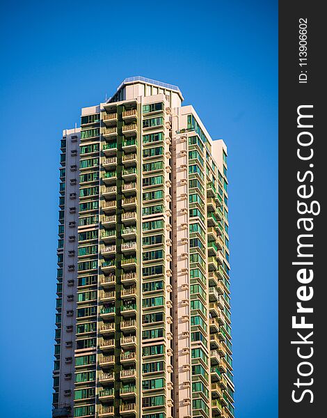 High Rise Condominium Building Against Blue Sky Background