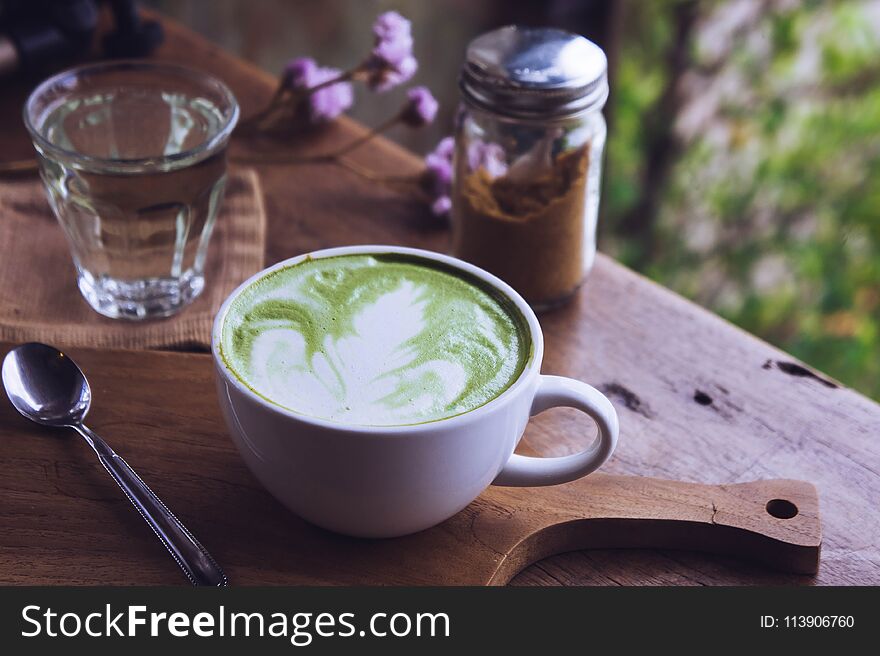 Green tea hot drink latte white cup on wood table aroma relax time in coffee shop.