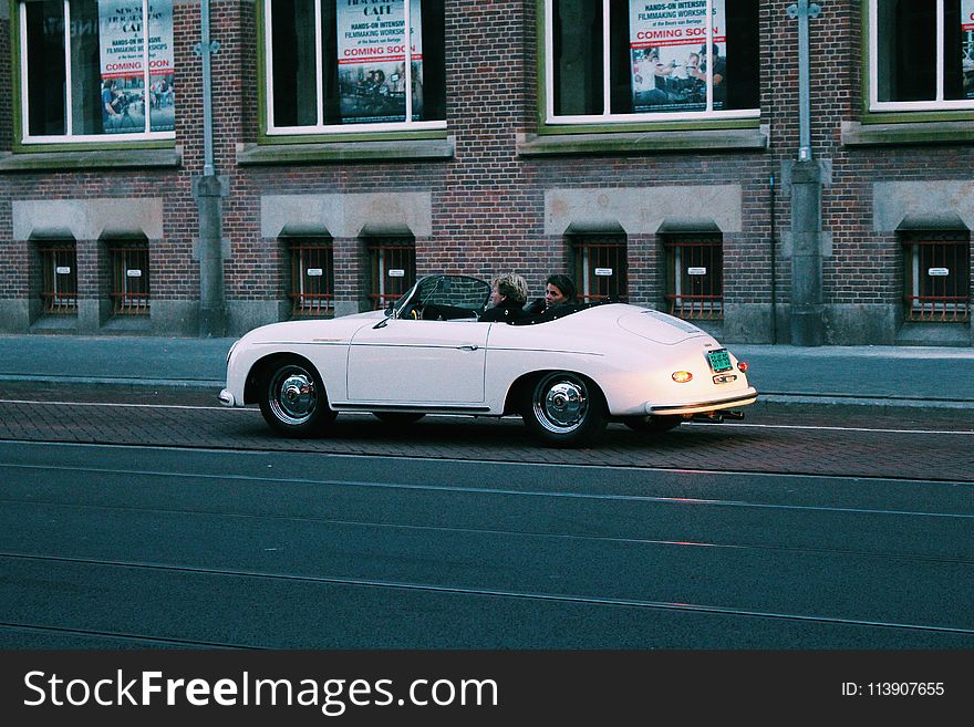 Two People Riding White Classic Convertible Car