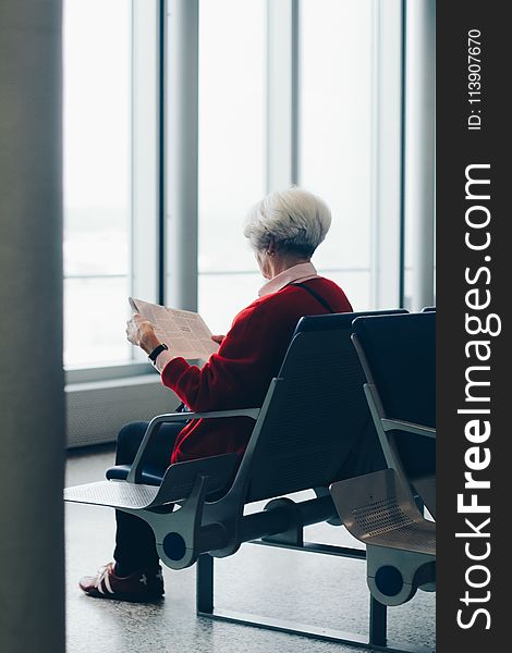 Person In Red Coat Sitting On Chair