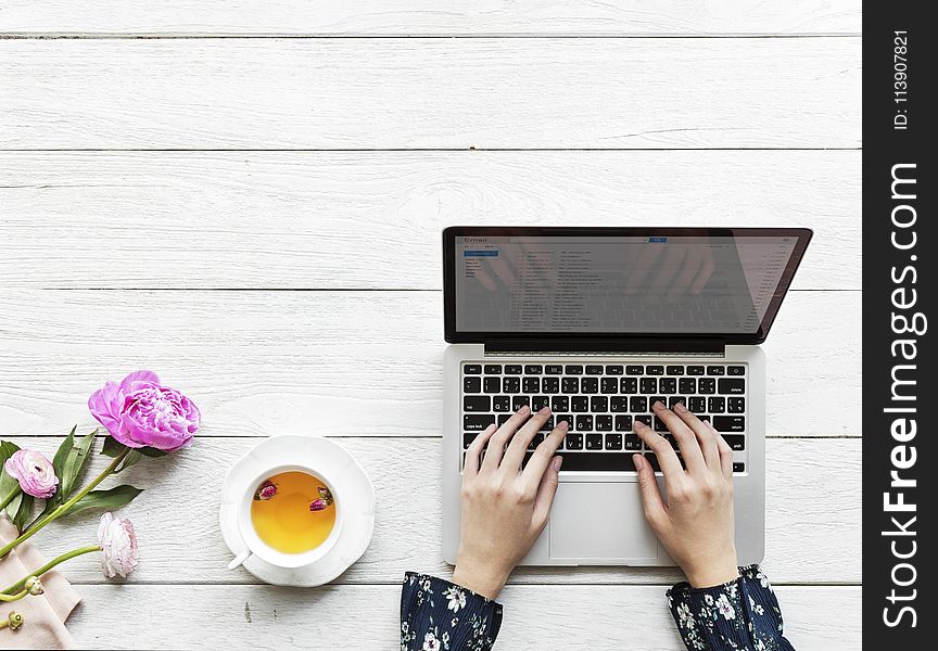 Macbook Pro Beside White Cup And Saucer On Table