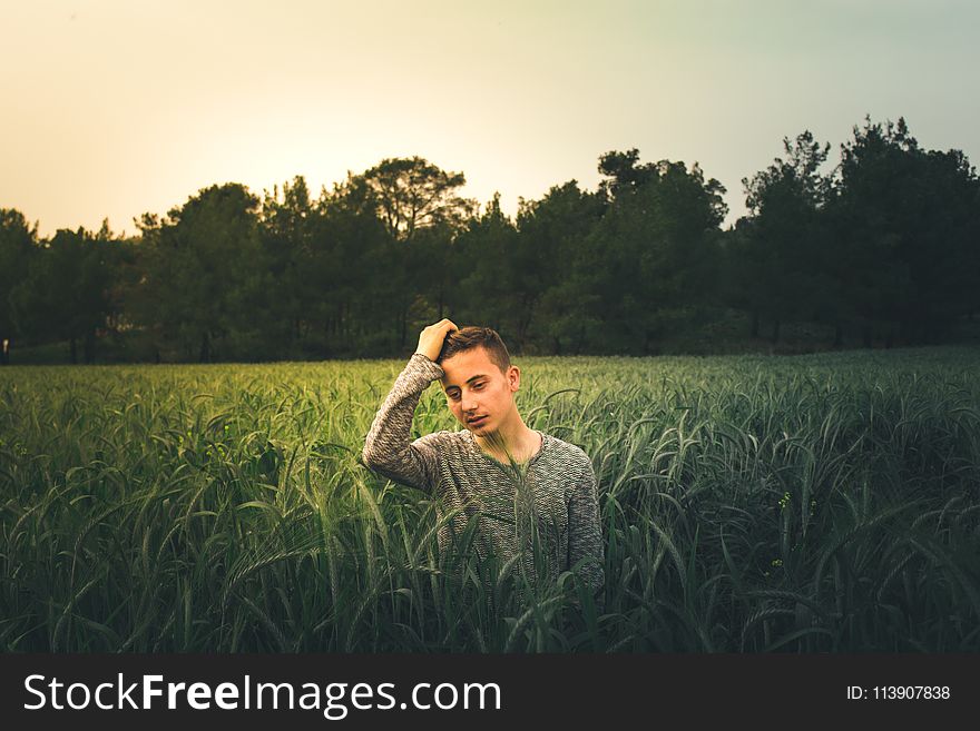Man Wearing Gray Sweatshirt Standing On Grass Field