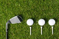 Golf Club And Three Balls Lie Beautifully On The Green Grass Royalty Free Stock Image