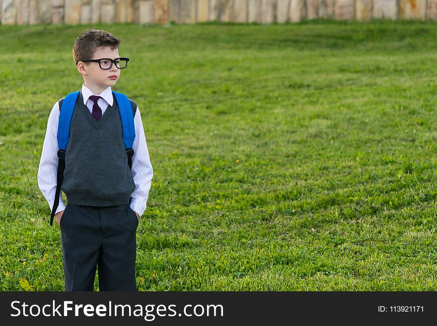 Schoolboy with a backpack looking at the place for your inscription