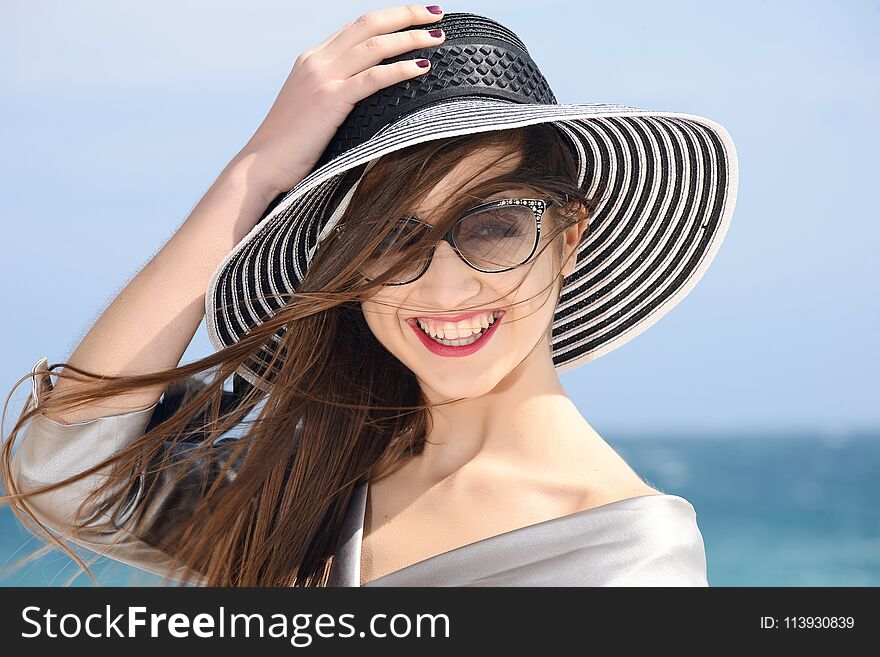 Beautiful girl dressing fashion outfit and sunglasses happy by the sea. Beautiful girl dressing fashion outfit and sunglasses happy by the sea