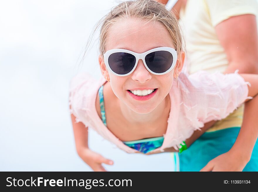 Little Girl Outdoors During Summer Vacation Have Fun With Father. Portrait Of A Kid Upside Down On A Sky Background