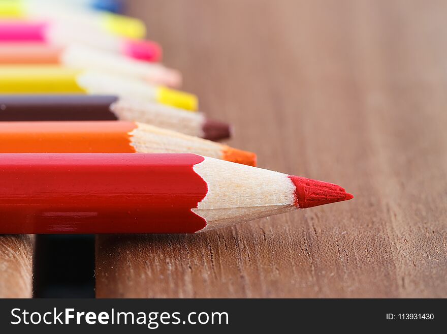 Set of colored pencils with a single sharp one symbolizing leadership concept