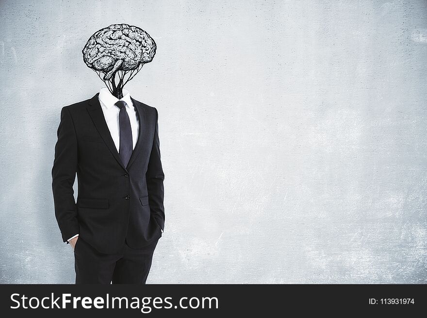 Brain headed businessman on concrete wall background. Brainstorming and success concept